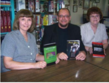 Author and Ashland native Thomas M. Malafarina sits with Ashland Public Library librarians Rene Hardnock left and Ann Helwig. They are holding the three books he authored, which were donated to the library Friday.